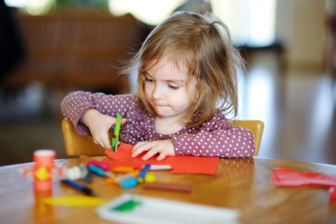 Preschool Girl cutting colorful paper