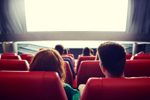 People staring at a movie theatre screen.