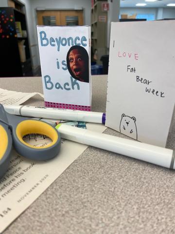 A photo of craft supplies and two zines. One is titled, "Beyoncé is Back" and the other, "I Love Fat Bear Week"