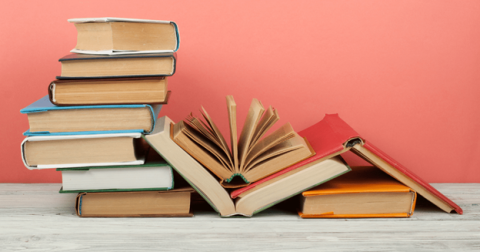 Photo of several stacks of books, 2 of which are open