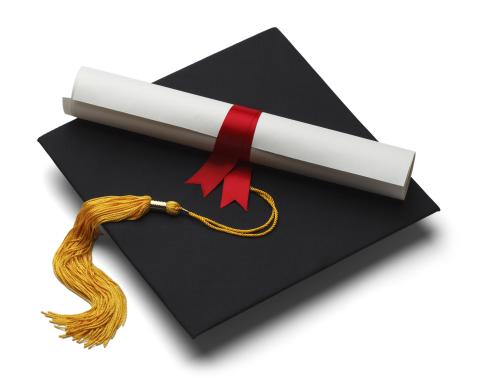 Graduation cap with gold tassel along with rolled up diploma tied with a maroon ribbon