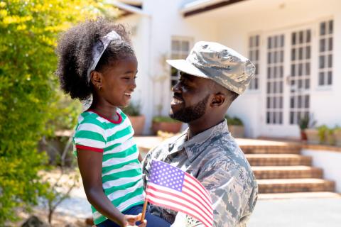 male soldier holding his daughter