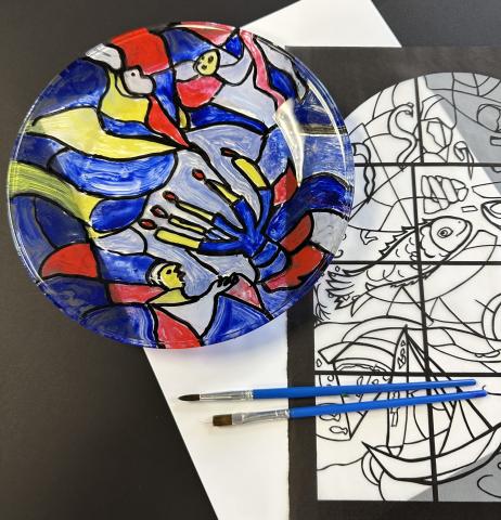 Stained glass plate with two paint brushes