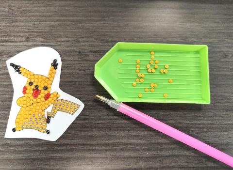 Pikachu sticker with diamond art beads, tray, and tool.