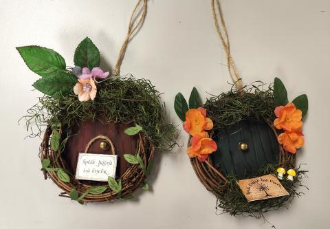 Two circular ornaments shaped like hobbit doors with a wreath around the edges.