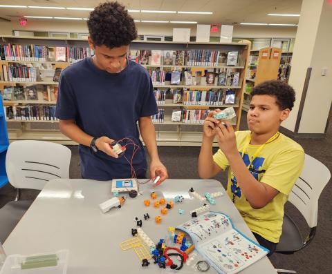 Two teens putting together robotic parts