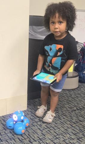 child with Dash coding robot