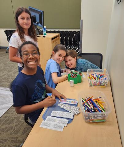 A couple teens color and decorate their bookmarks.