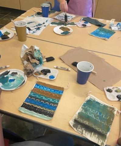 Mali mud cloth designs on a table with craft supplies. 