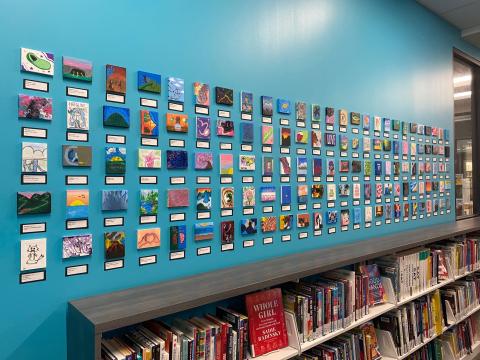 small canvases placed on a teal wall