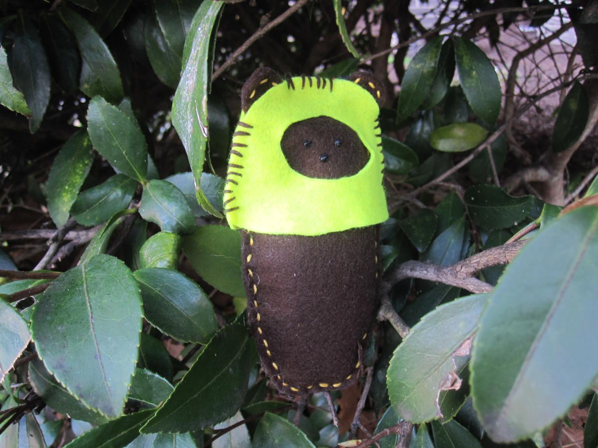 brown and yellow Ewok feltie surrounded by green leaves