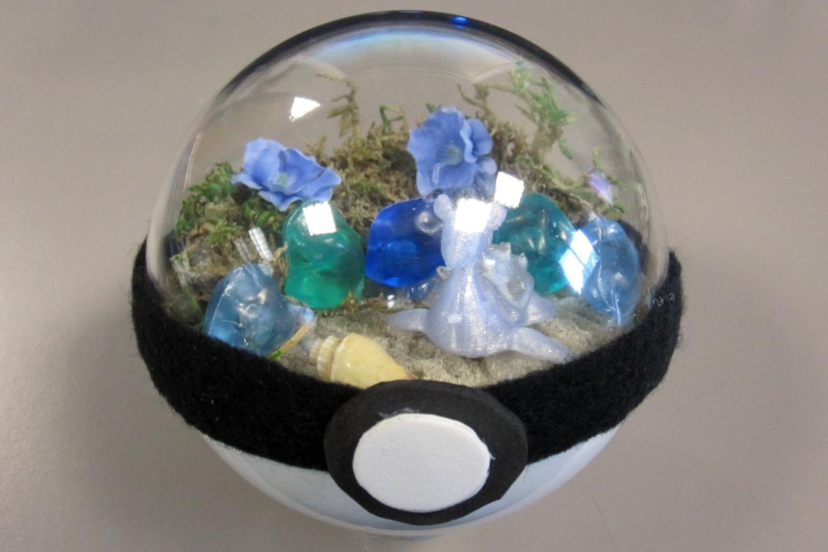 Pokeball shaped terrarium with blue Lapras inside