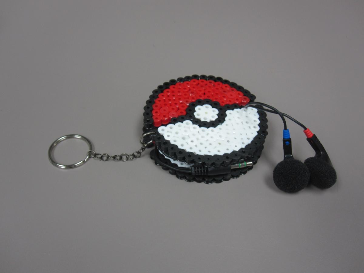 Pokeball holder made of Perler beads holding ear buds