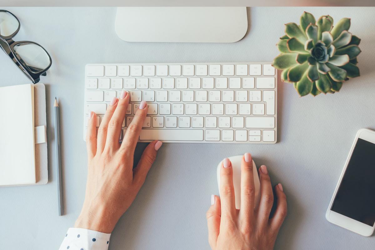 Two hands are shown from above typing on a keyboard.