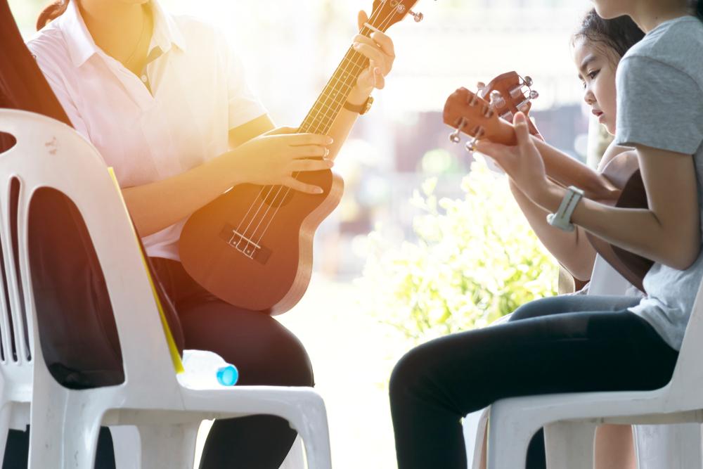 practicing Ukulele play with tutor