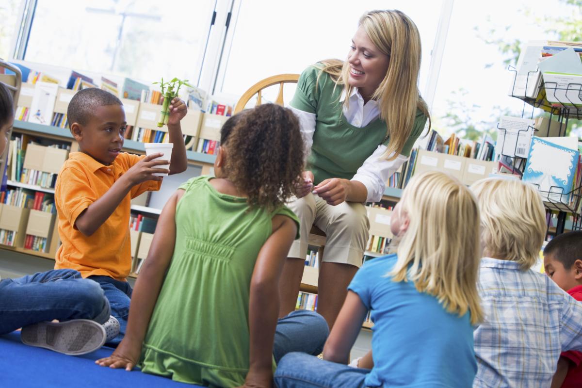 Children sitting on the floor facing the teacher