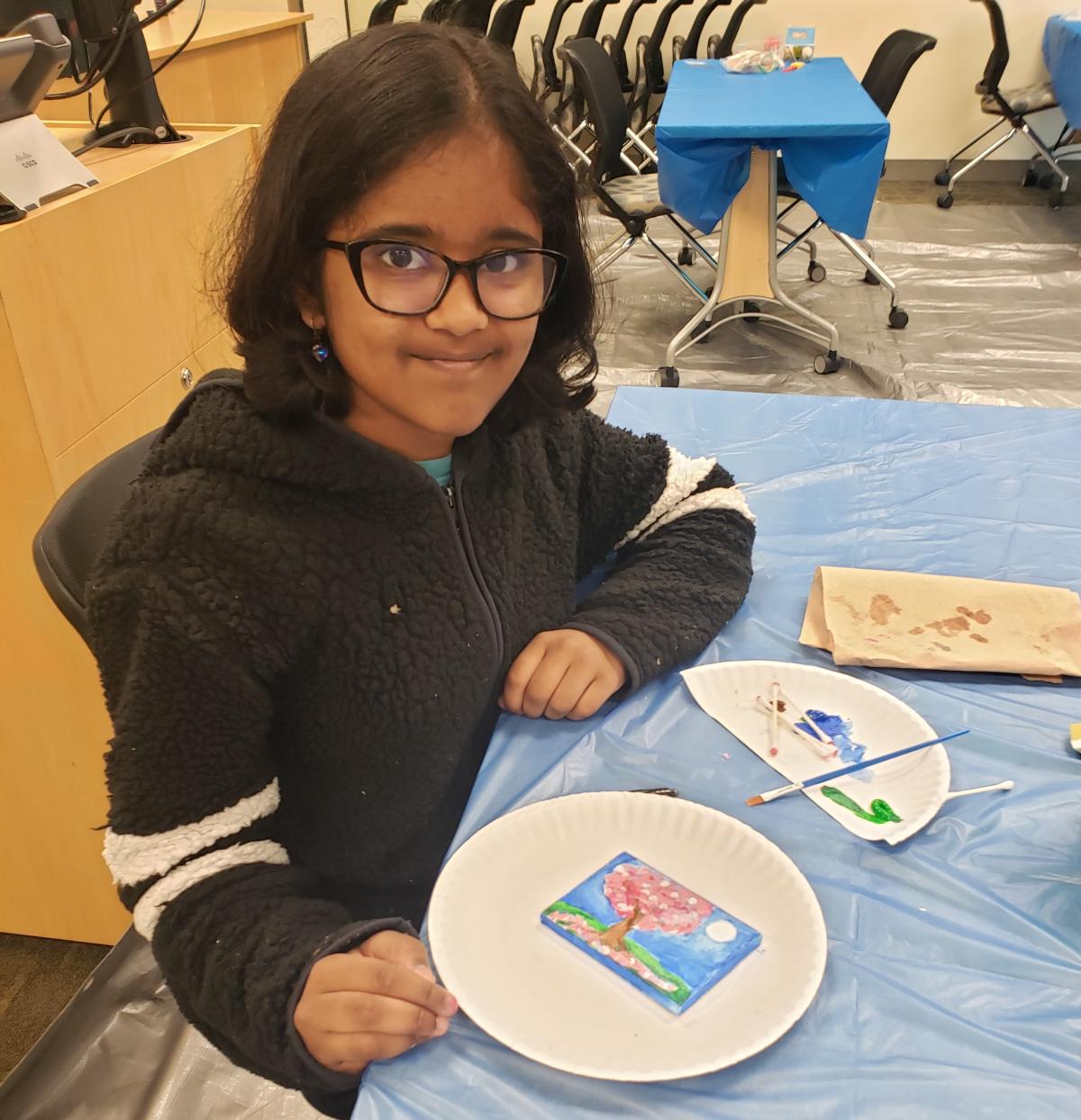 Teen painting on a tiny canvas