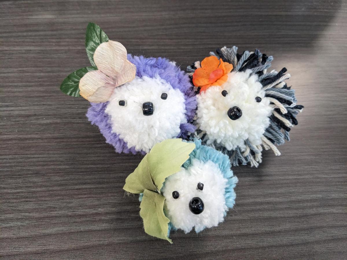 purple pom pom hedgehog, black and white pom pom hedgehog, and sage pom pom hedgehog