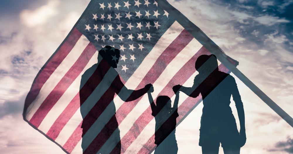 American flag with a family casting a shadow through it.