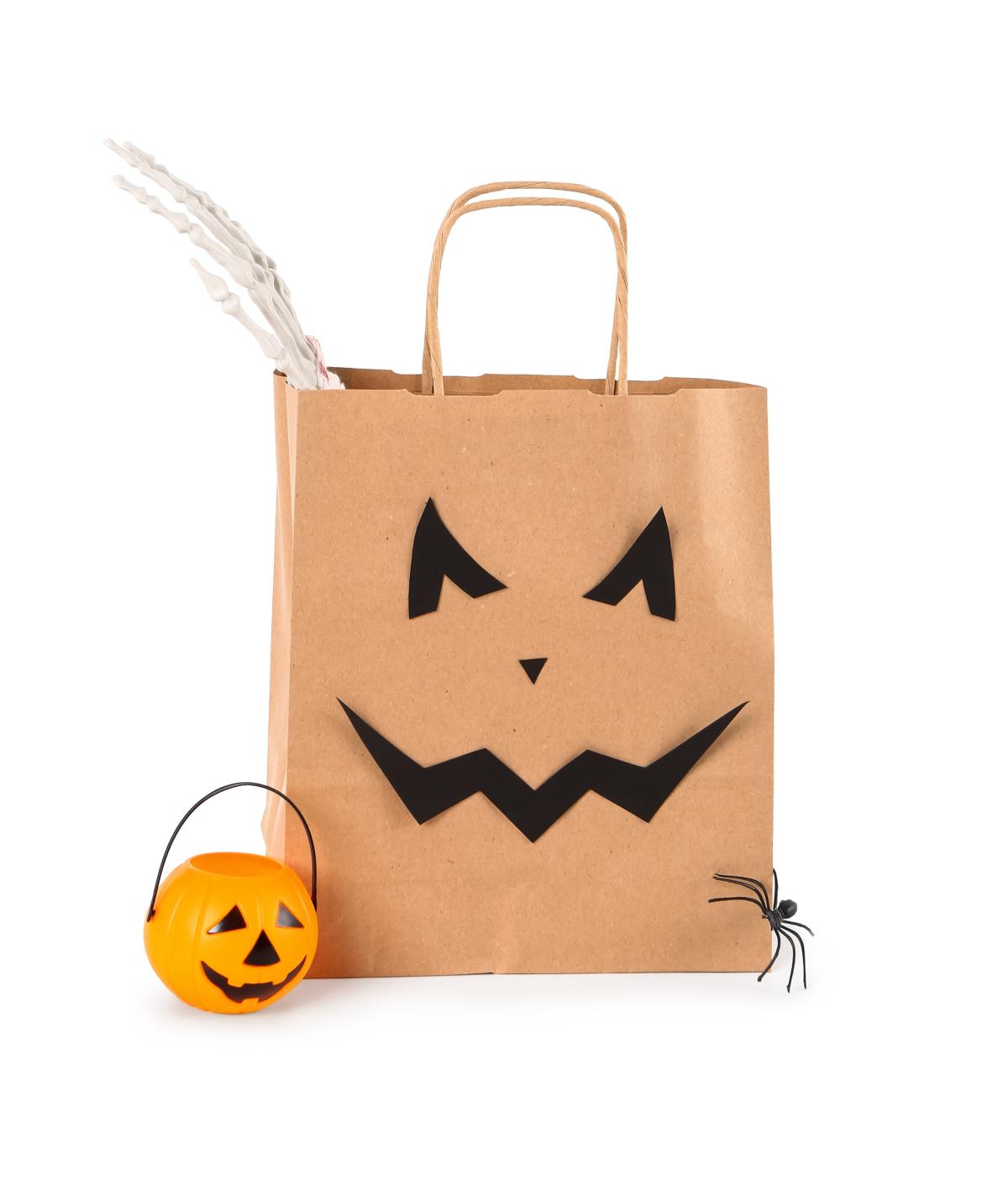 A brown paper bag decorated like a Jack-o-Lantern for Halloween