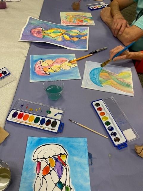 Watercolor art of jellyfish with materials on the table