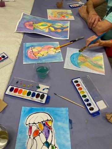 jellyfish paintings and supplies on a table