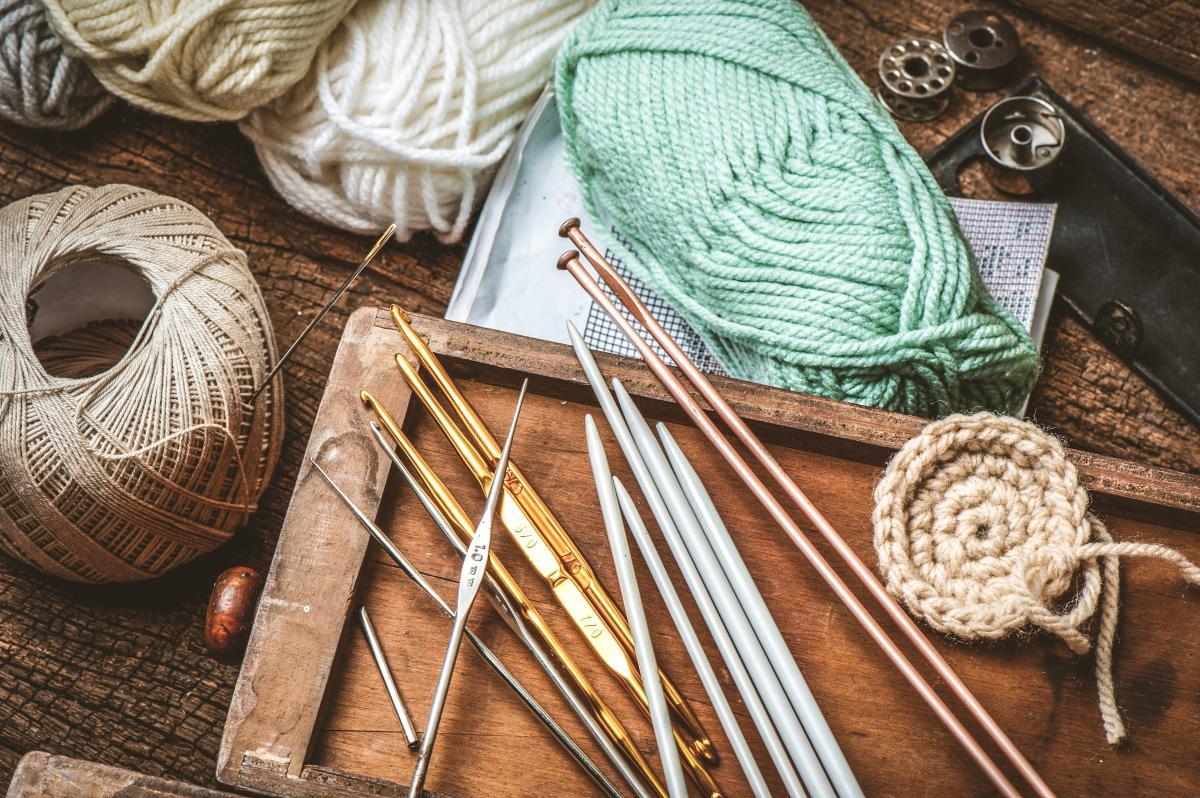 Image of yarn, thread, and assorted knitting needles and crochet hooks