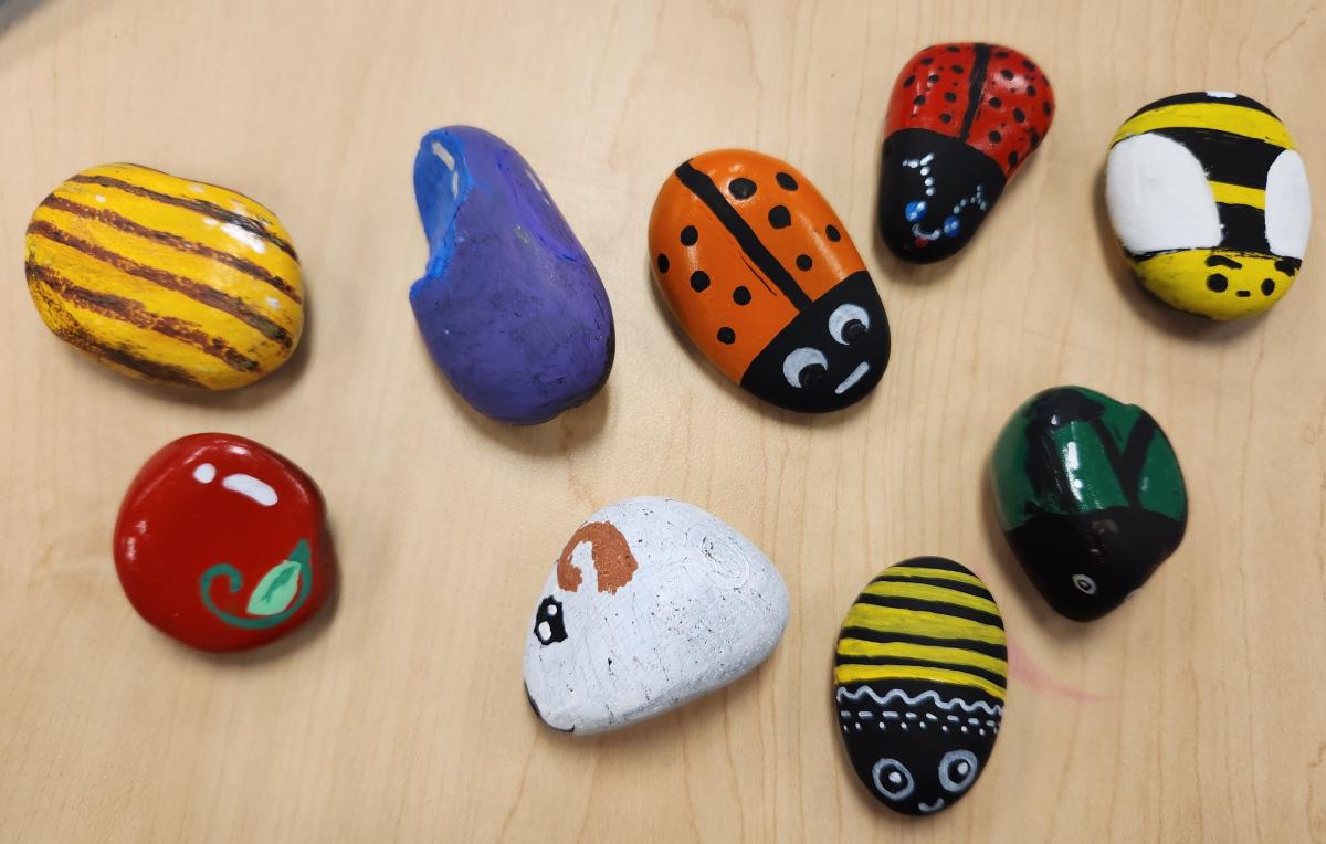 Sample of rocks teens painted in various bugs and food designs.