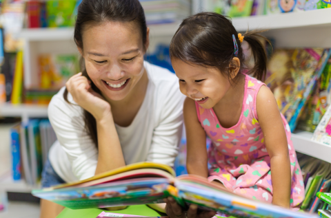 Adult reading a picture book with a young child