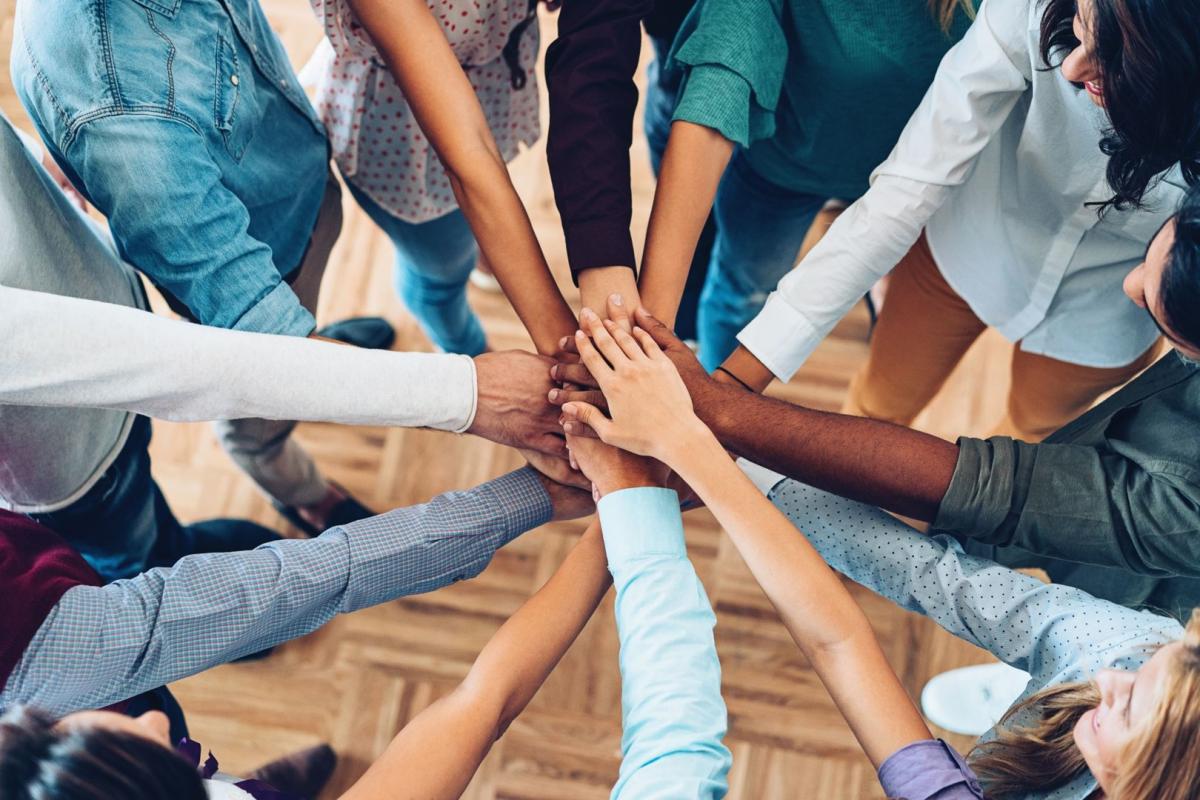 Diverse group of people with joined hands